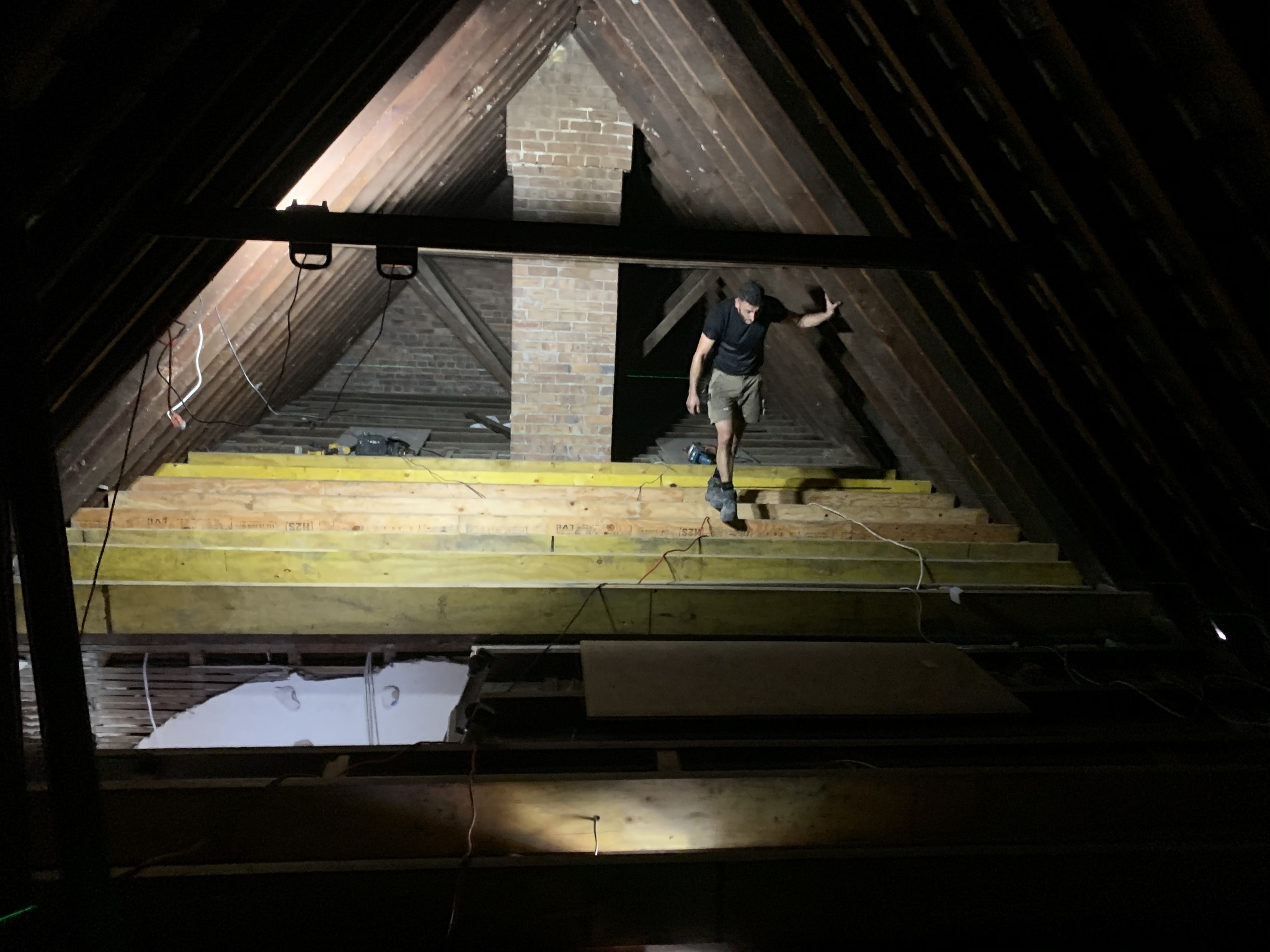 Arncliffe attic before - dark roof space with timber joists