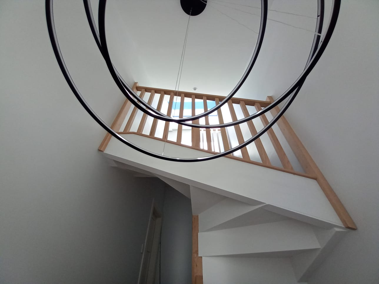 Bronte view from below showing double-height stairwell with circular pendant and skylight