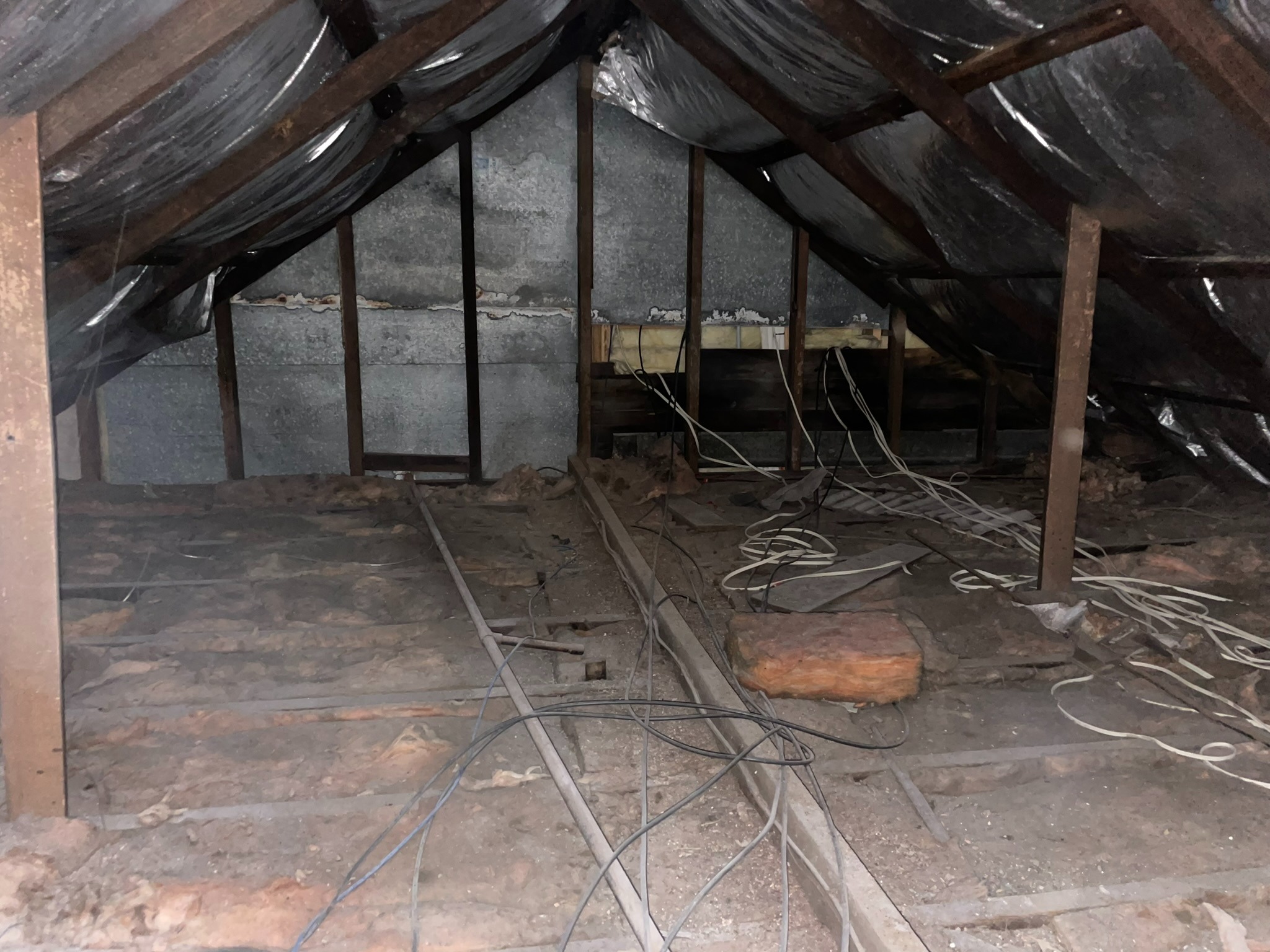 Concord attic before - dark space with exposed rafters and debris